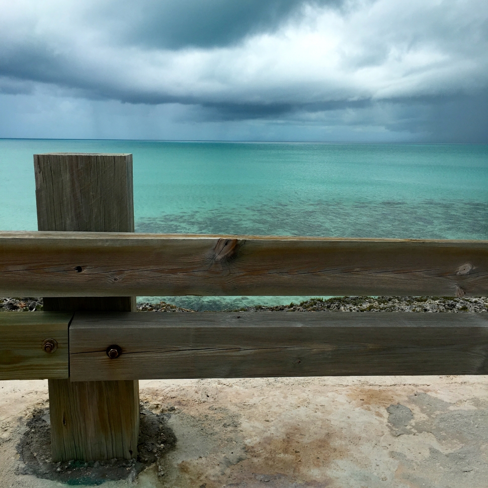 brown wooden fence near body of water under cloudy sky at daytime preview